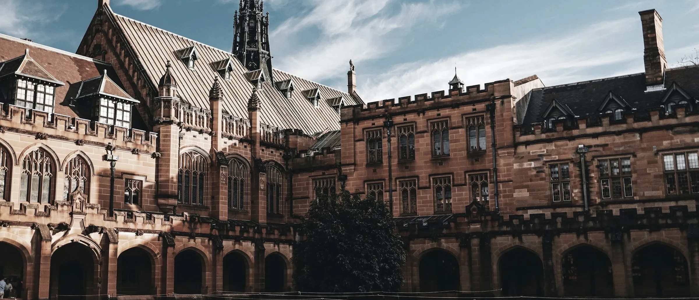 A sandstone university building with a clock tower - the kind of institutional setting where the WCMS recovery played out